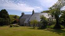 The idyllic farmhouse is surrounded by beautiful, mature gardens and large lawns.