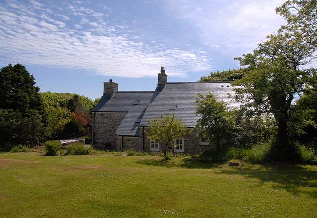 The idyllic farmhouse is surrounded by beautiful, mature gardens and large lawns.