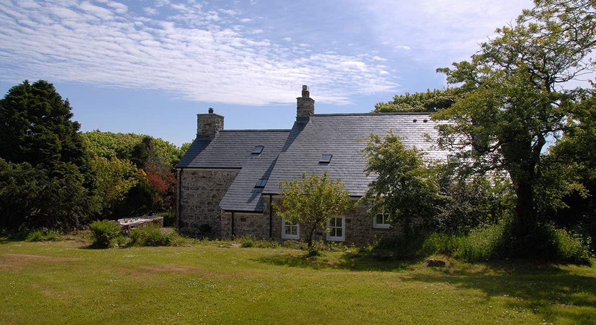 The idyllic farmhouse is surrounded by beautiful, mature gardens and large lawns.