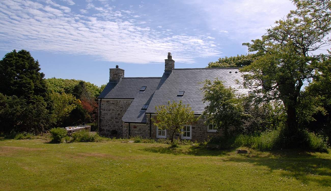 The idyllic farmhouse is surrounded by beautiful, mature gardens and large lawns.