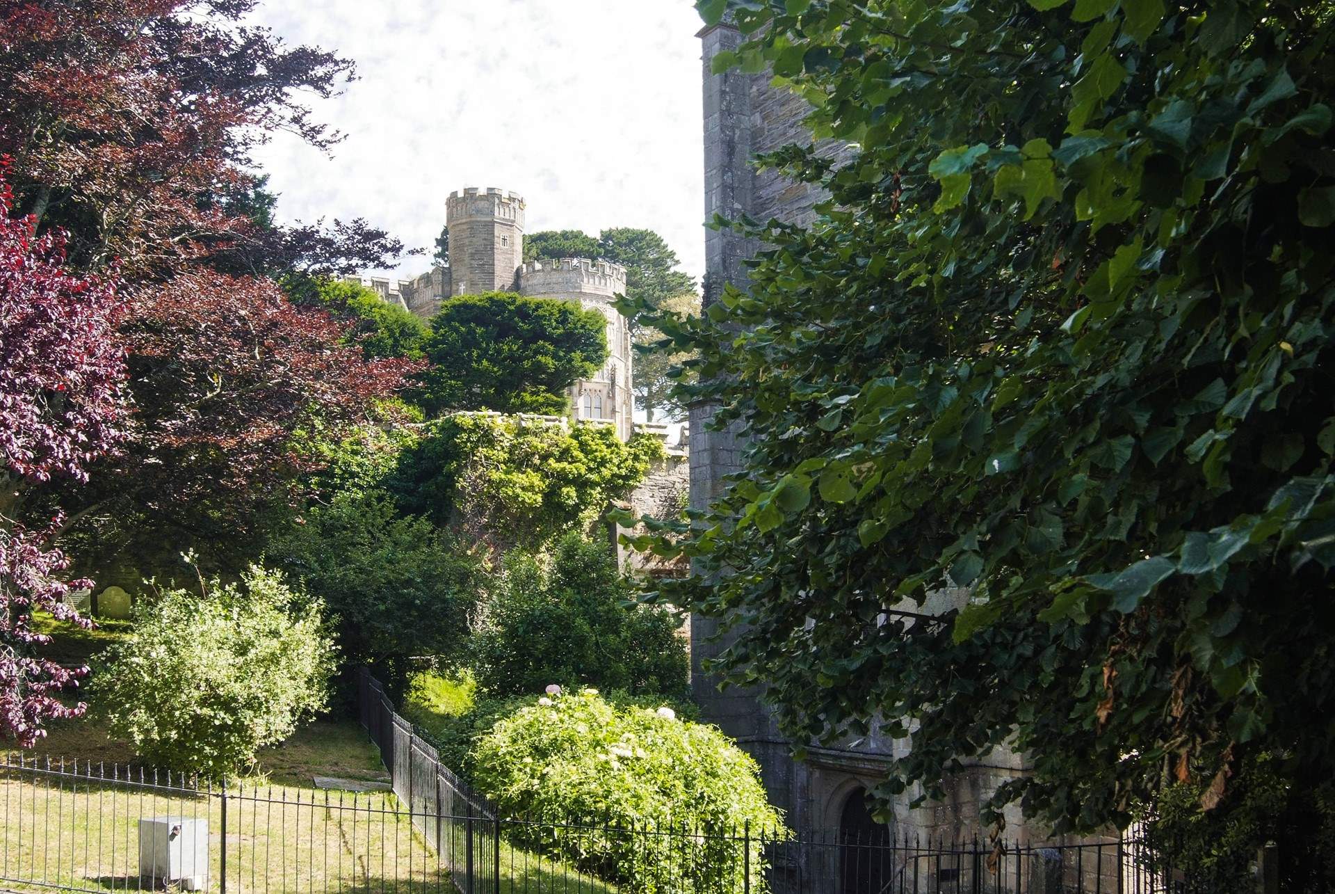 Looking up at castellated Place House from the square by the church.