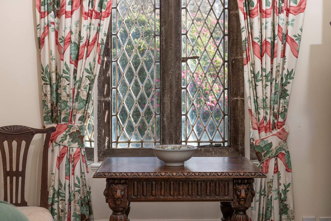 The patterned curtains perfectly dress the mullion windows.