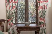 The patterned curtains perfectly dress the mullion windows.