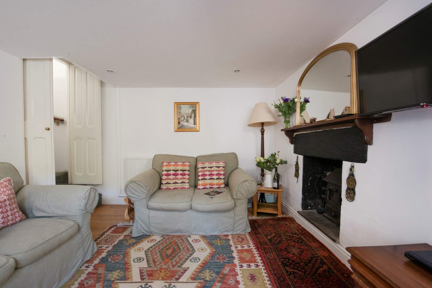 The cottage sitting-room is super cosy with little doors closing off the stairs.