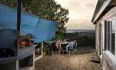 The outdoor area has a large table and chairs, pizza oven and barbecue.  - Thumbnail Image