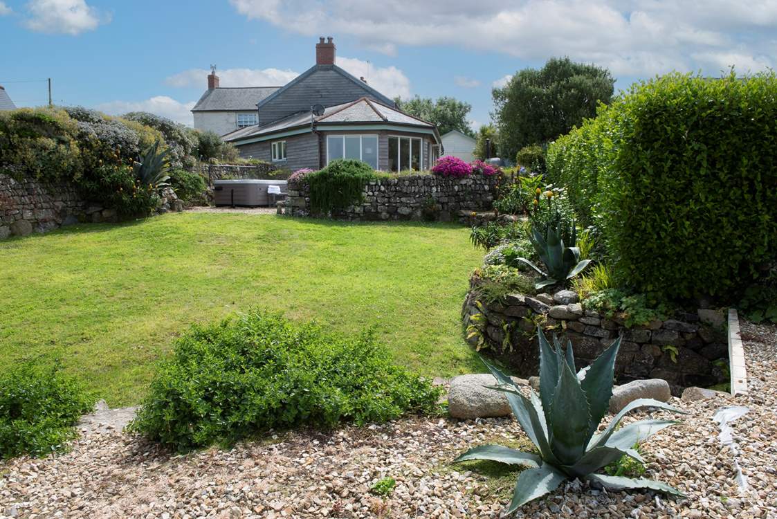 From the garden looking back up to the hot tub and outdoor dining-area.