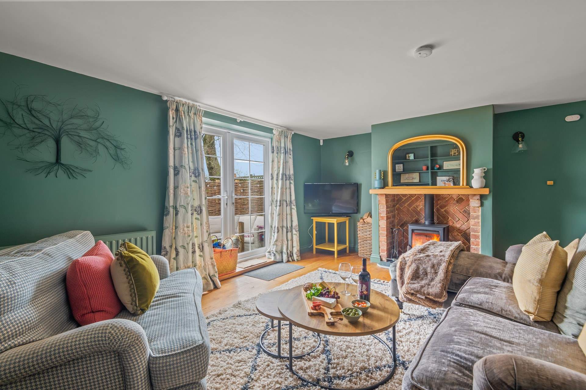 The beautiful sitting-area with glowing wood-burner and direct access to your enclosed patio-area.