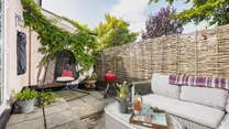 Your outside space offers a beautiful spot to sit back and relax in, especially in that fabulous swinging chair.