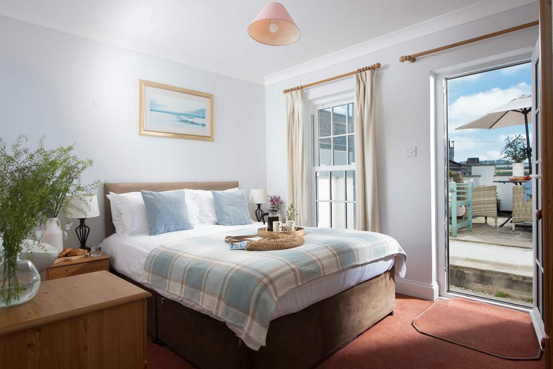 Bedroom 1 has a king-size bed and access to the outside patio area.