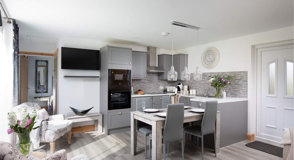 The open plan living space is adorned with grey tones.