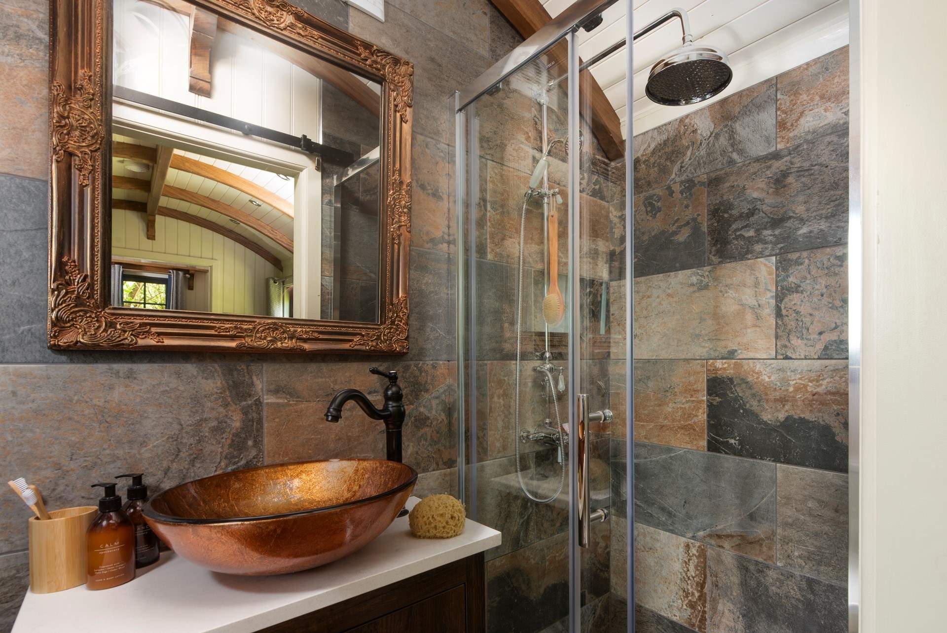 The stylish bathroom has a luxurious waterfall shower.
