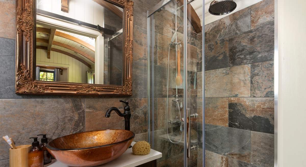 The stylish bathroom has a luxurious waterfall shower.