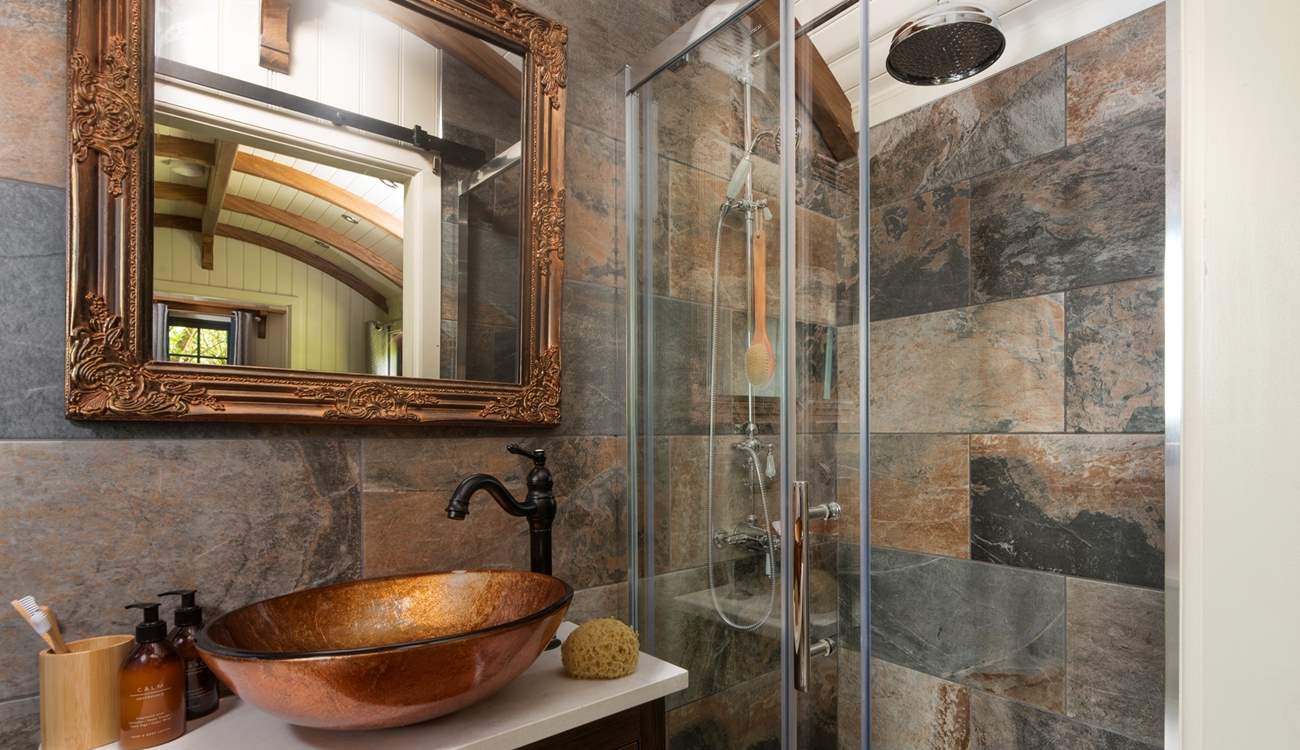 The stylish bathroom has a luxurious waterfall shower.