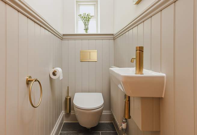 Contemporary gold fittings in the downstairs cloakroom add a delightful twist.