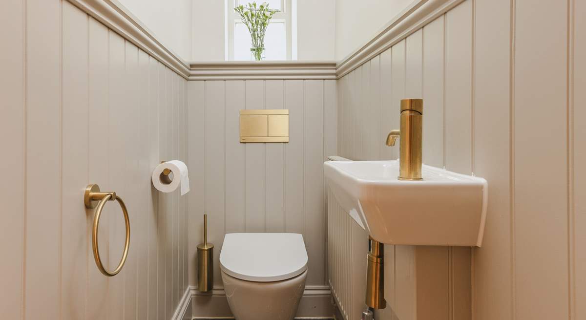 Contemporary gold fittings in the downstairs cloakroom add a delightful twist.