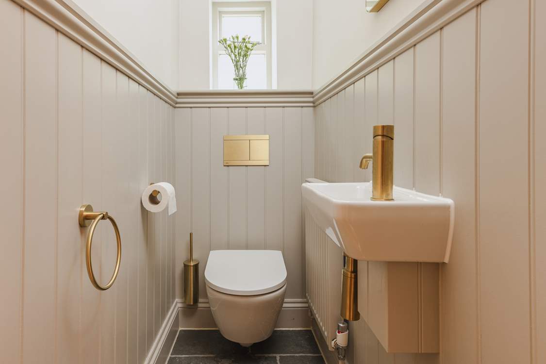 Contemporary gold fittings in the downstairs cloakroom add a delightful twist.