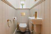 Contemporary gold fittings in the downstairs cloakroom add a delightful twist.