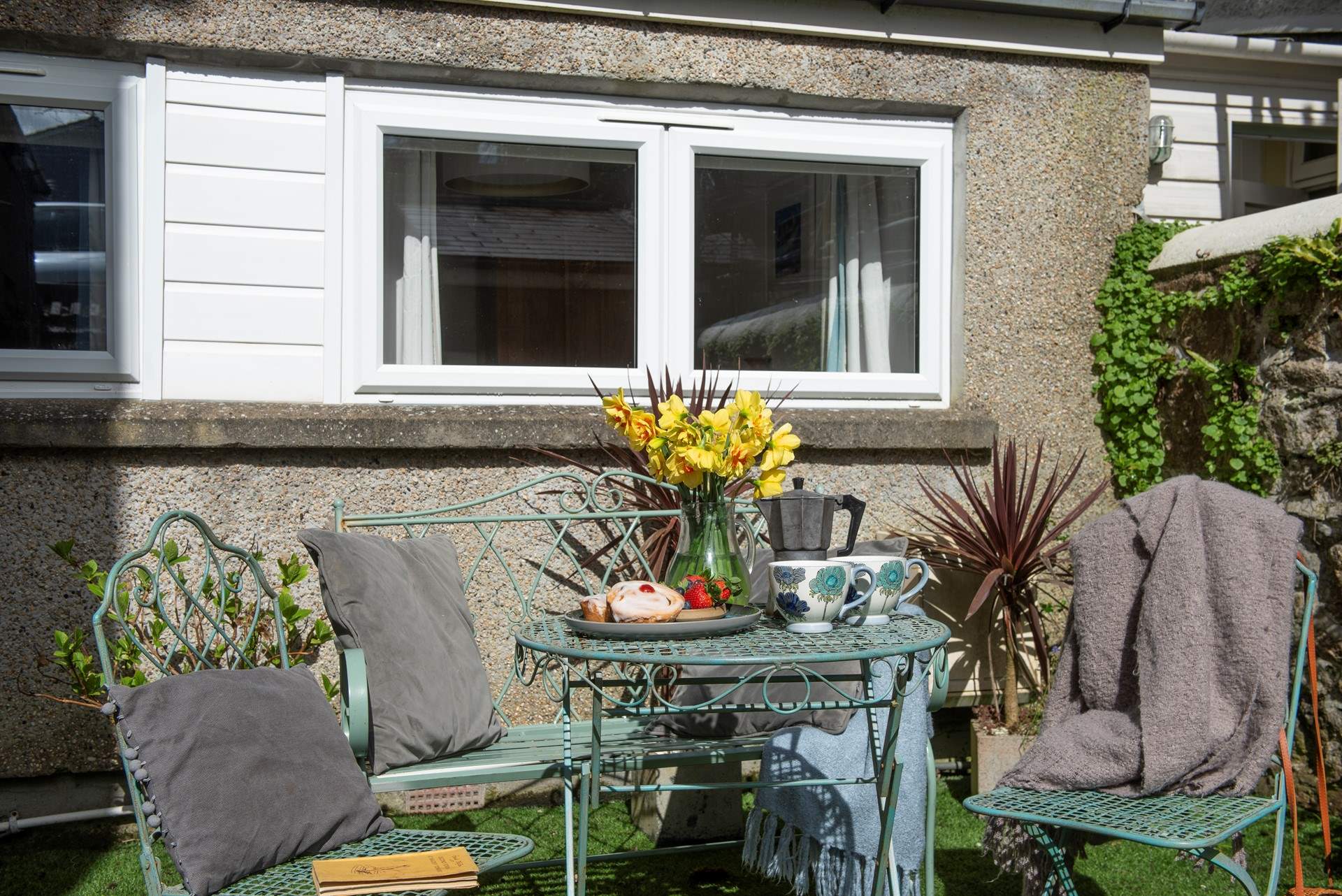 The pretty outside table and chairs are to the left of the communal entrance adjacent to a neighbouring property. 