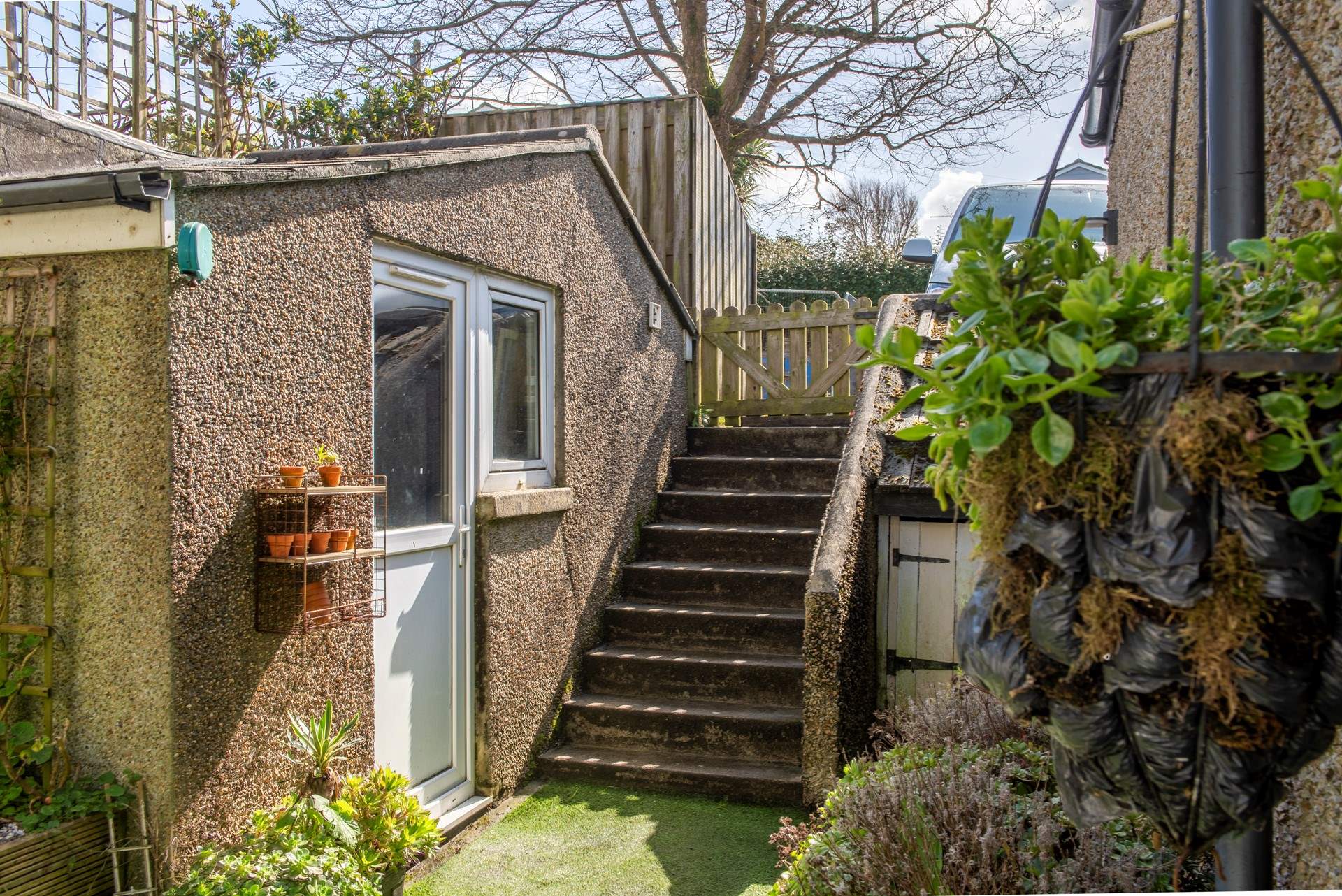 Steps lead from the private car parking space. This communal outhouse has a tumble-drier to refresh your beach towels.