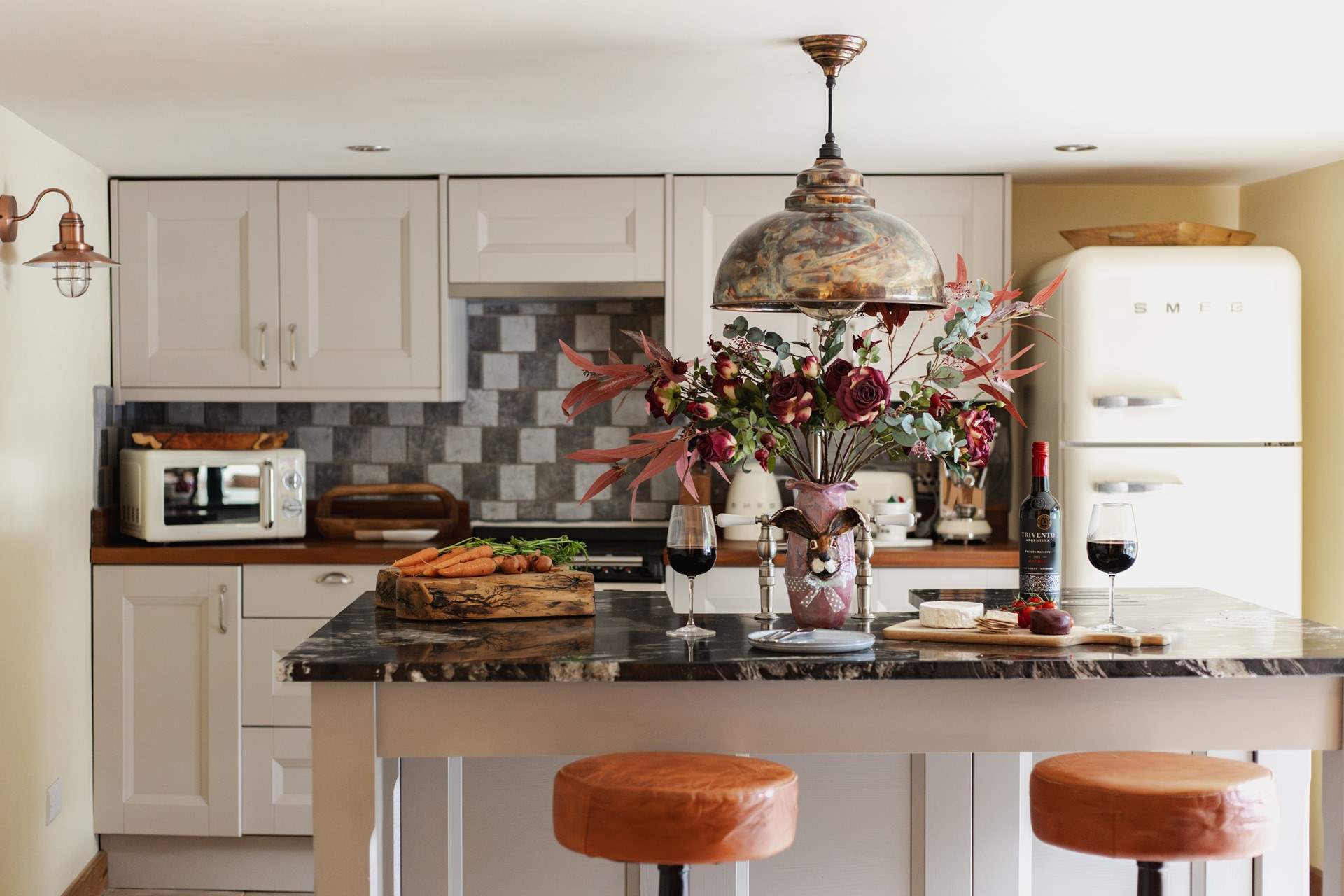 The beautiful cream kitchen is the perfect place to enjoy a glass of wine.