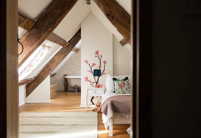 Bedroom four has a single bed and sloping ceilings and original beams