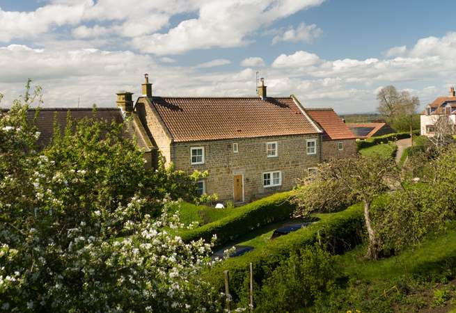 A picturesque farmhouse in a beautiful setting.