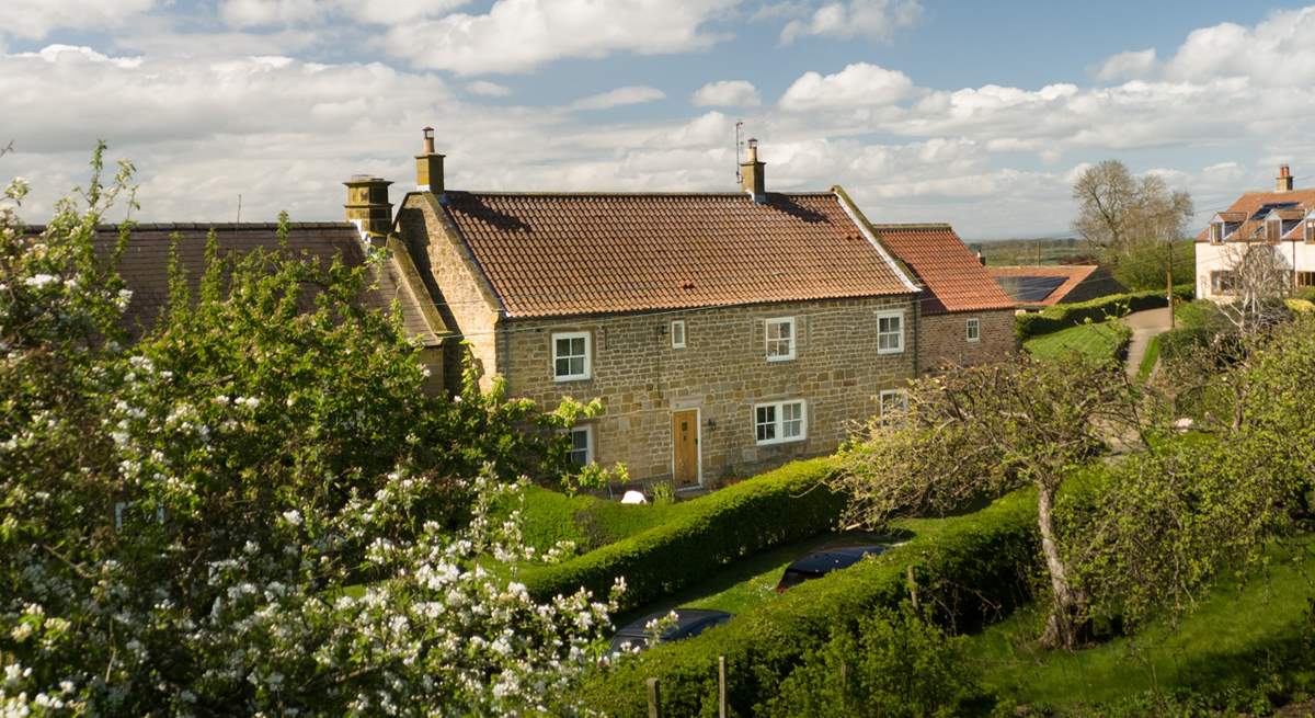 A picturesque farmhouse in a beautiful setting.