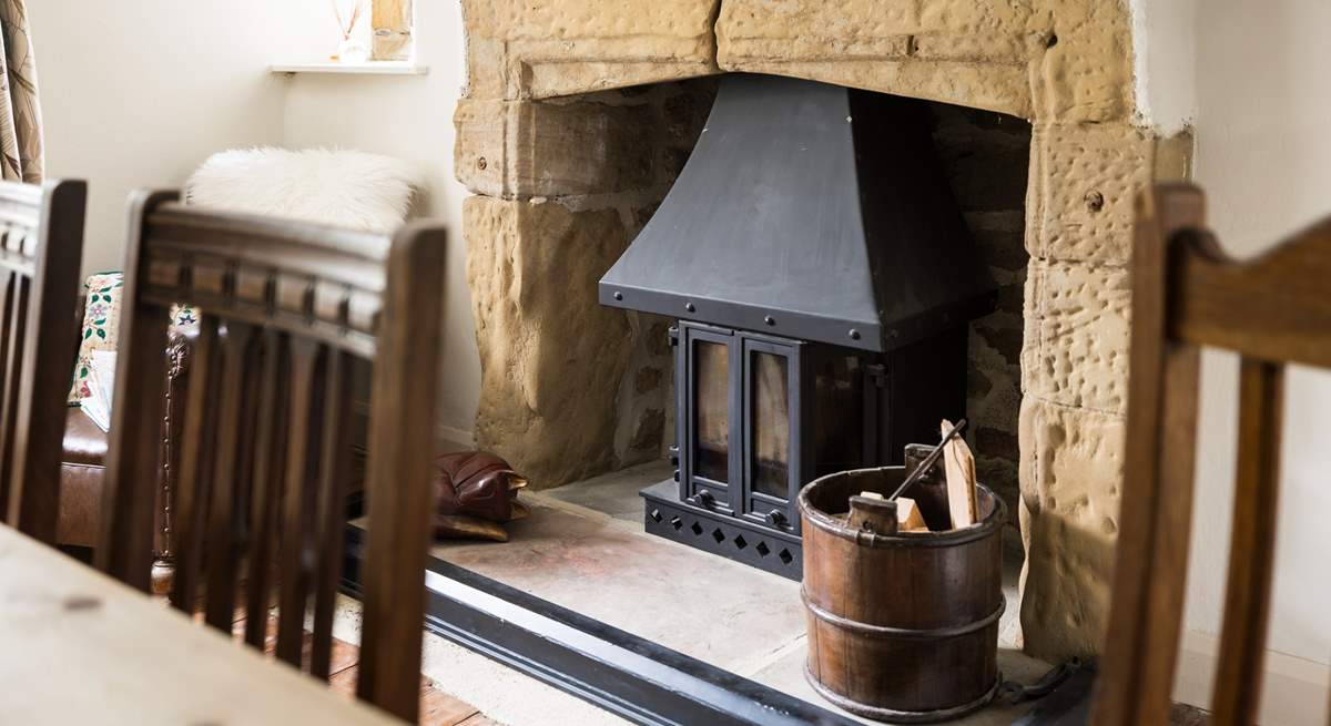 The wood-burner sits in a beautiful fireplace.