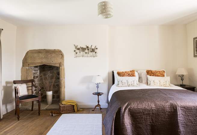 The elegant king-size bedroom with original fireplace.