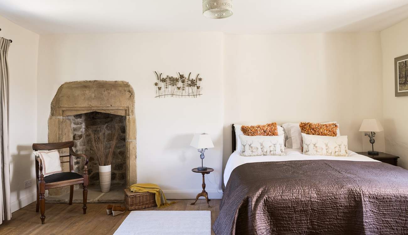 The elegant king-size bedroom with original fireplace.