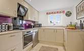 The stylish kitchen with a gorgeous purple splashback. - Thumbnail Image