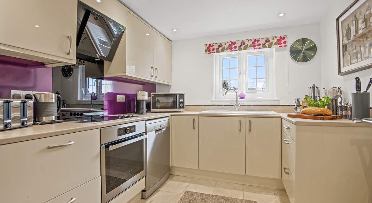 The stylish kitchen with a gorgeous purple splashback.