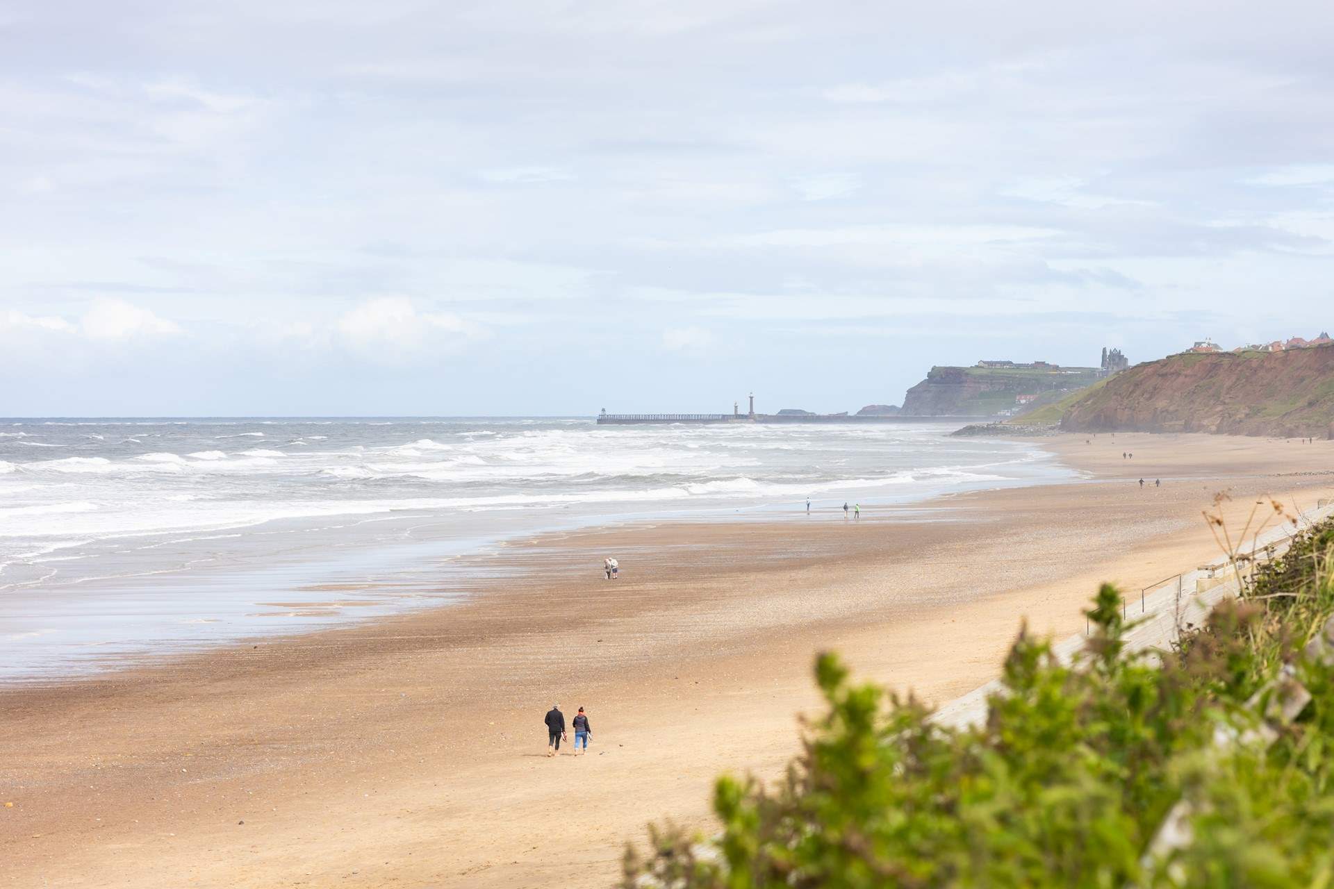 Iconic Whitby Abbey, as seen from Sandsend, sits on the cliffs looking over the town, walk along the piers or take a boat trip and look for Minke whales or dolphins.