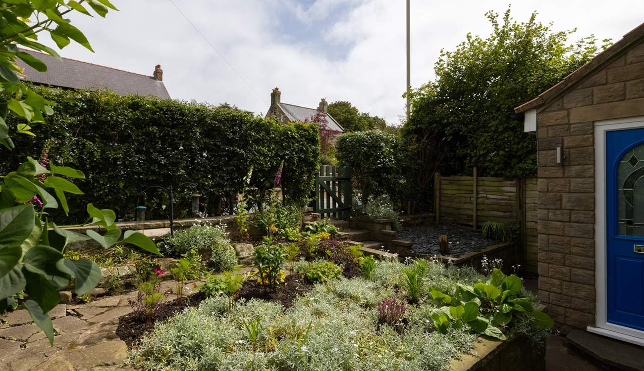 The front tiered garden is bursting with plants and flowers. 
