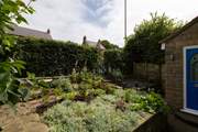 The front tiered garden is bursting with plants and flowers.
