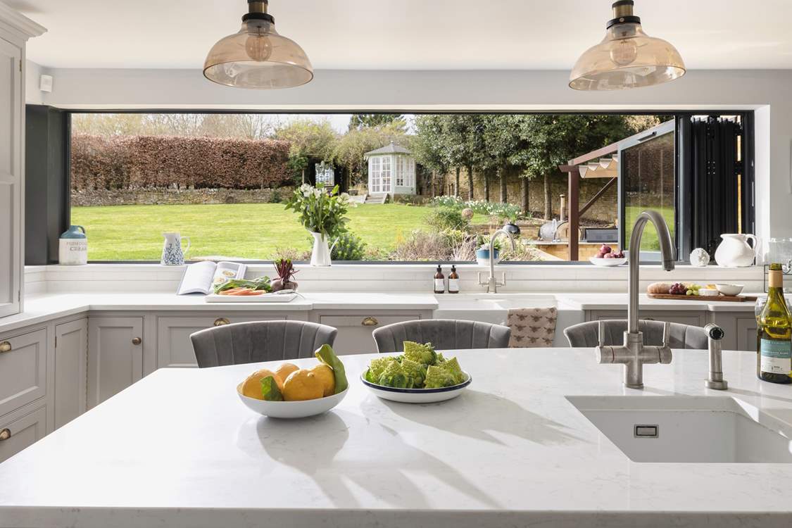 The incredible bi-folding window in the kitchen transforms the area into the perfect space to entertain, bringing the outside in.