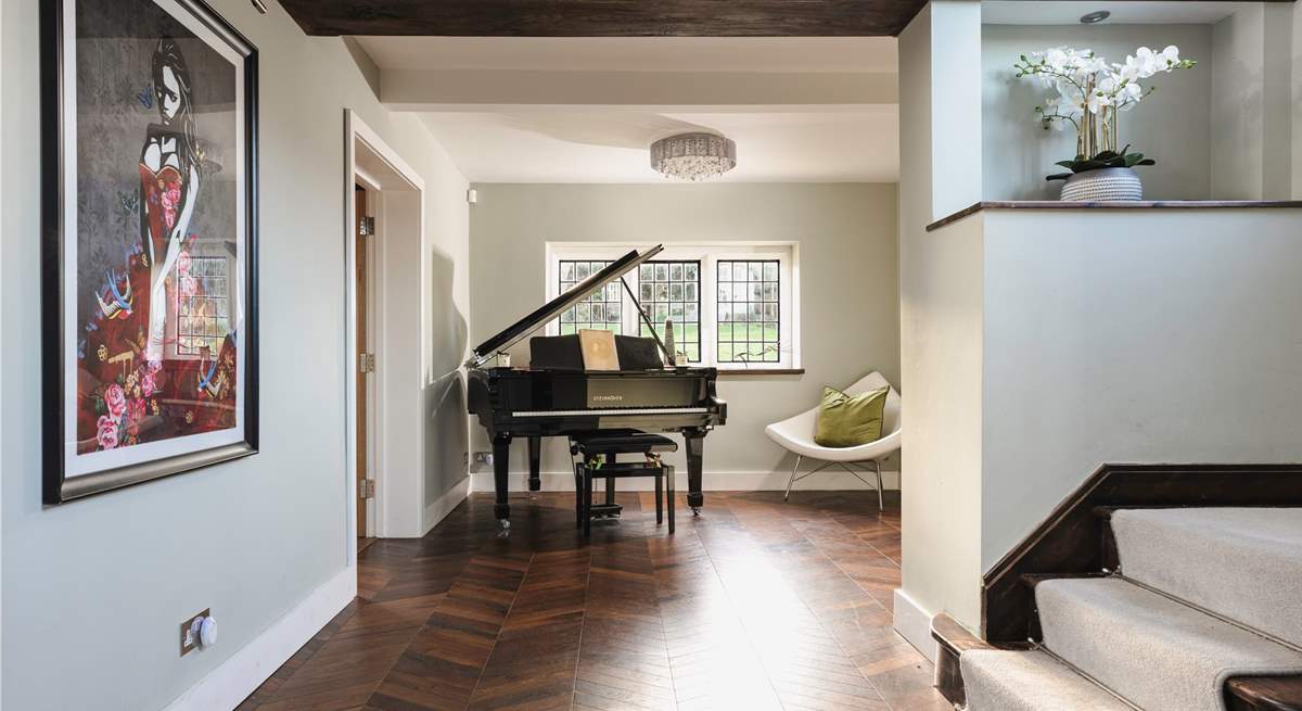 As you enter the hallway you are greeted by a beautiful grand piano and contemporary pieces of art.