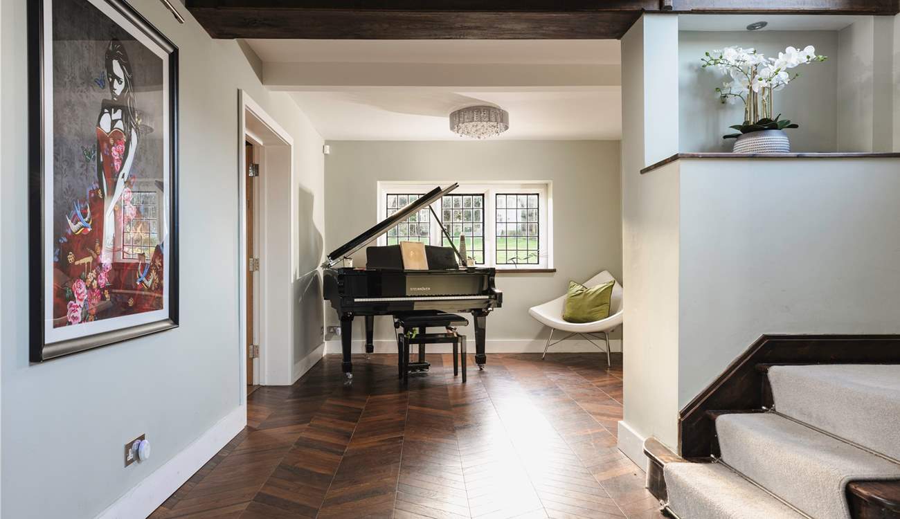 As you enter the hallway you are greeted by a beautiful grand piano and contemporary pieces of art.