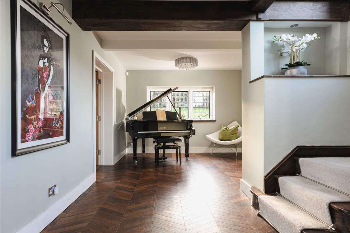 As you enter the hallway you are greeted by a beautiful grand piano and contemporary pieces of art.