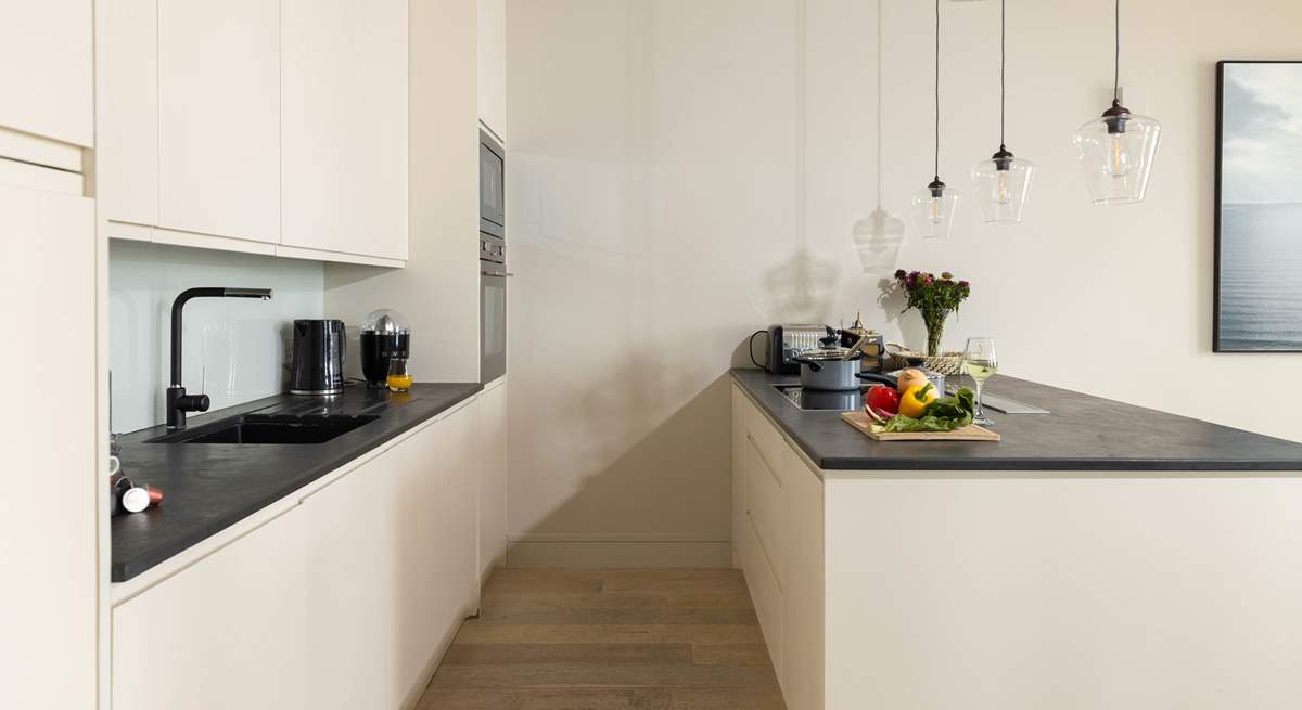 Sharp lines and clear zoning creates a perfect open plan room with the kitchen zone being part of the social hub of the apartment. 