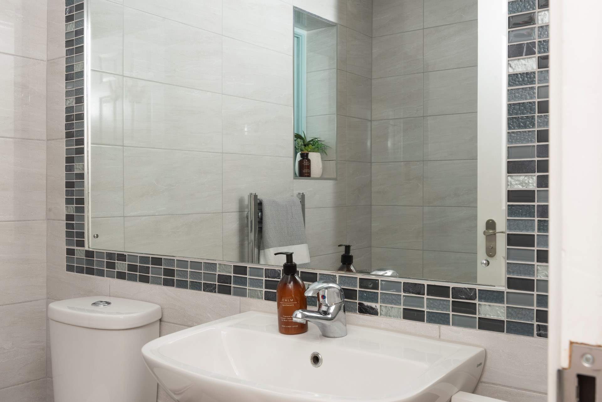 The family bathroom has a bath and electric shower over it. 