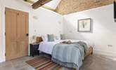 The lovely bedroom is open to the ceiling to highlight the original barn features. - Thumbnail Image