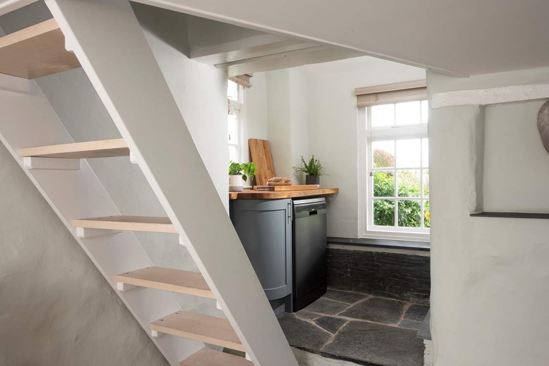 A couple of steps lead to a small utility-area and shower-room and the open-tread stairs up to the bedroom.