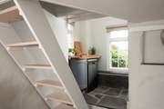A couple of steps lead to a small utility-area and shower-room and the open-tread stairs up to the bedroom.