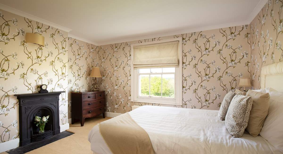 The main bedroom with ornamental fireplace is a heavenly retreat.