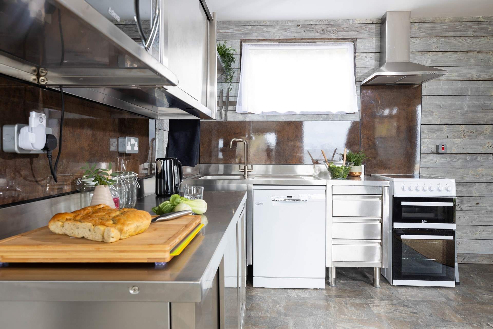 A clever industrial style kitchen fits beautifully into this gorgeous beach retreat.  