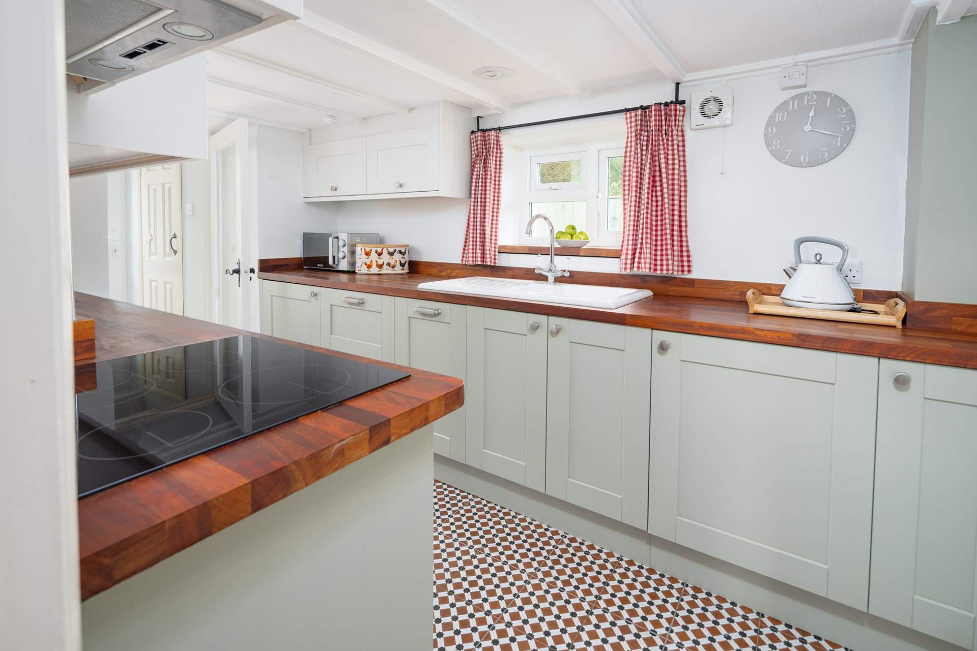Gorgeous, contemporary sage green kitchen, with a garden view. 