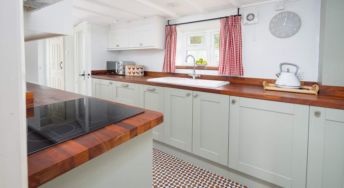 Gorgeous, contemporary sage green kitchen, with a garden view. 