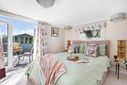This stylish bedroom benefits from doors leading out on to the patio, where there are far reaching rural views.