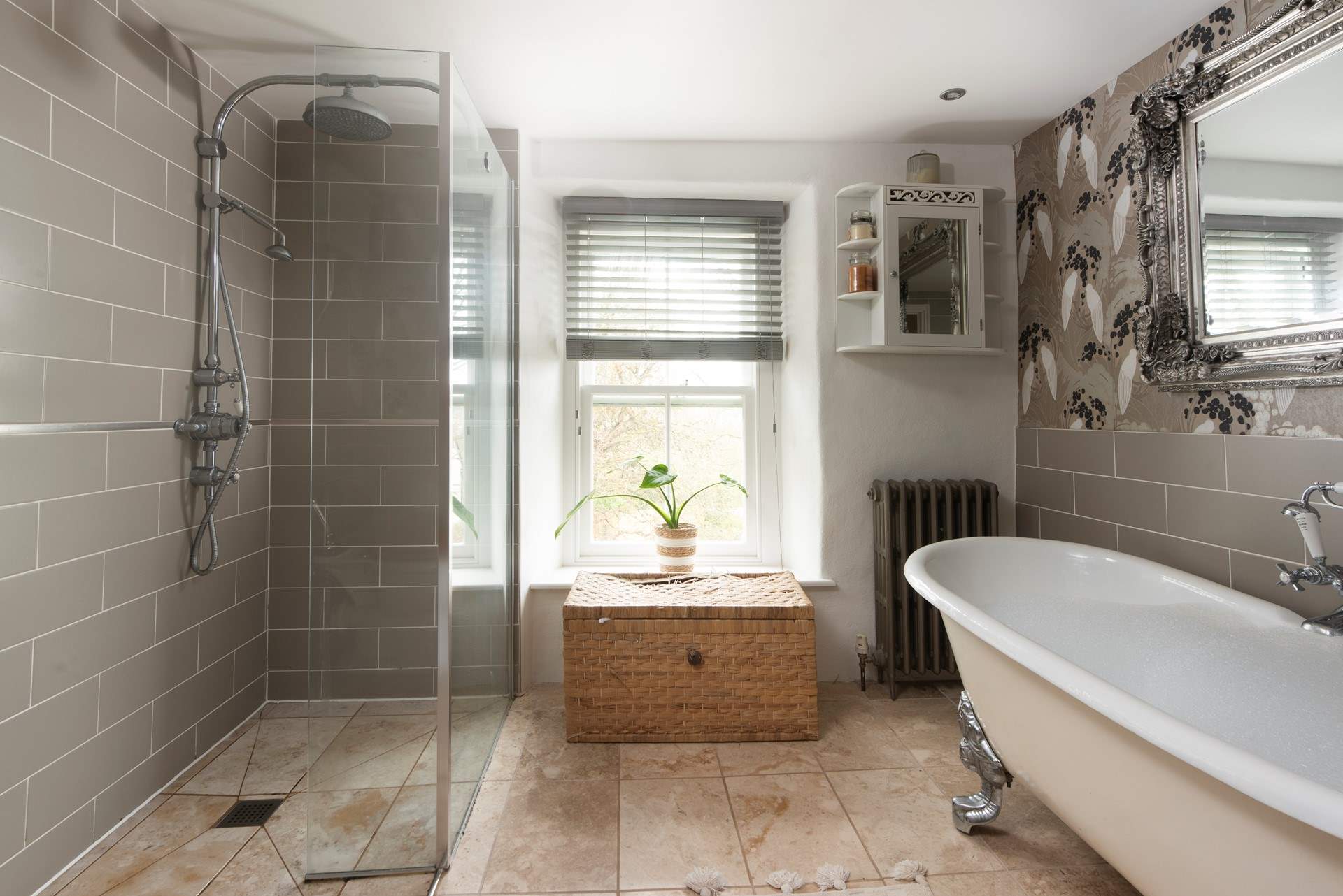 The tastefully curated family bathroom showing the spacious shower and enormous roll-top bath.